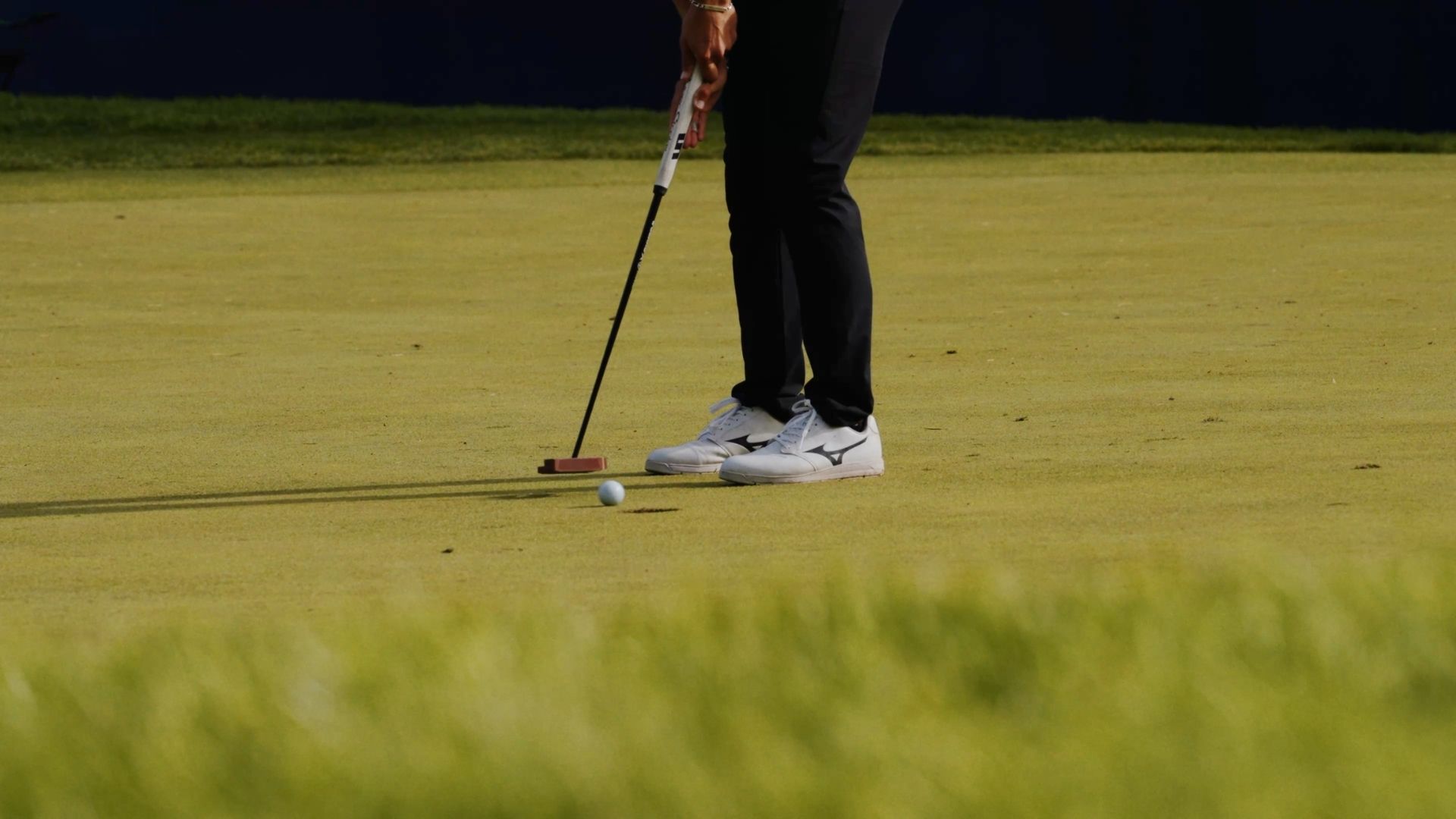 Golfer putting on green